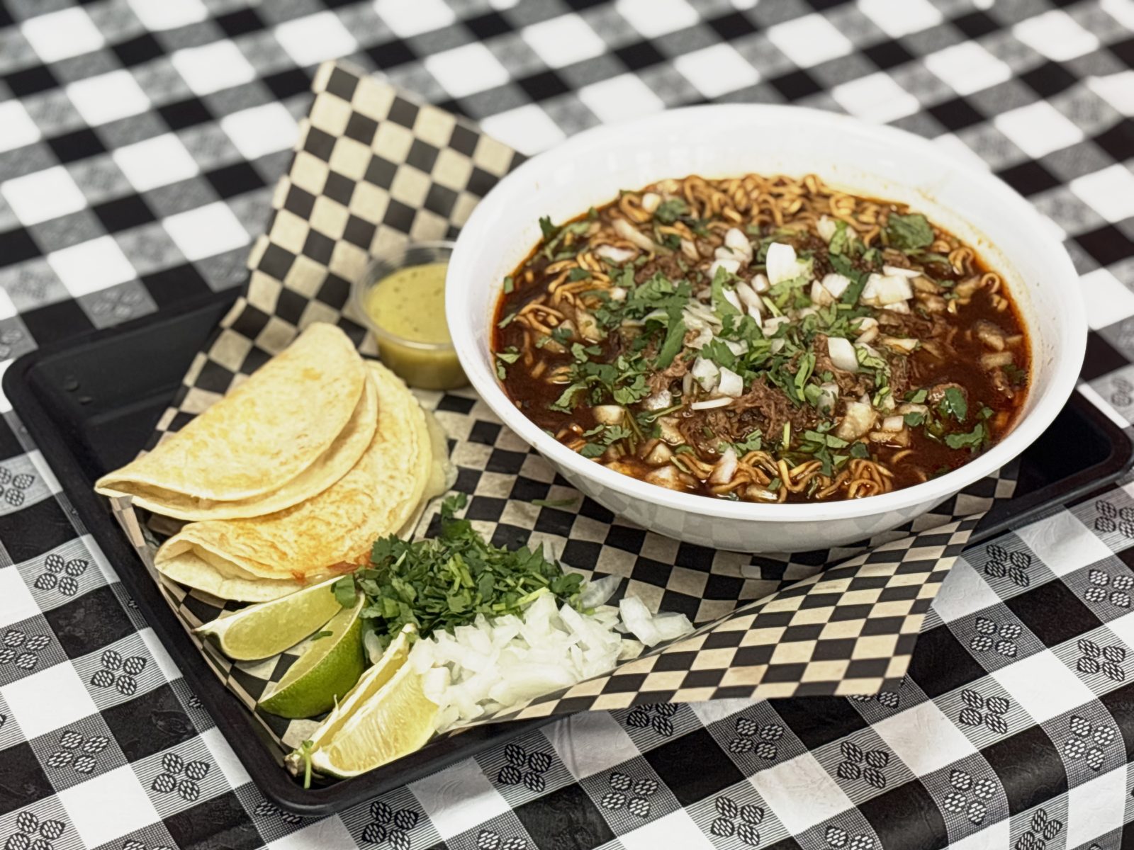 Bowl of birria ramen noodles in consomé with beef birria meat